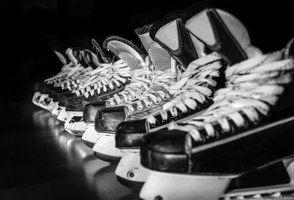 Hockey skates lined up in locker room HWave